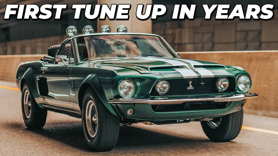 Front three-quarter view of the Thomas Crown Affair Mustang with white racing stripes and “First Tune Up in Years” headline