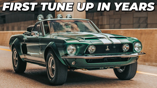 Front three-quarter view of the Thomas Crown Affair Mustang with white racing stripes and “First Tune Up in Years” headline