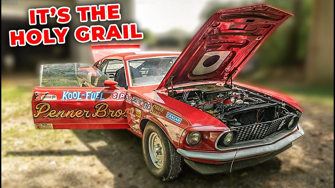 Front three-quarter view of a red vintage Mustang race car with hood open and racing decals plus Holy Grail headline