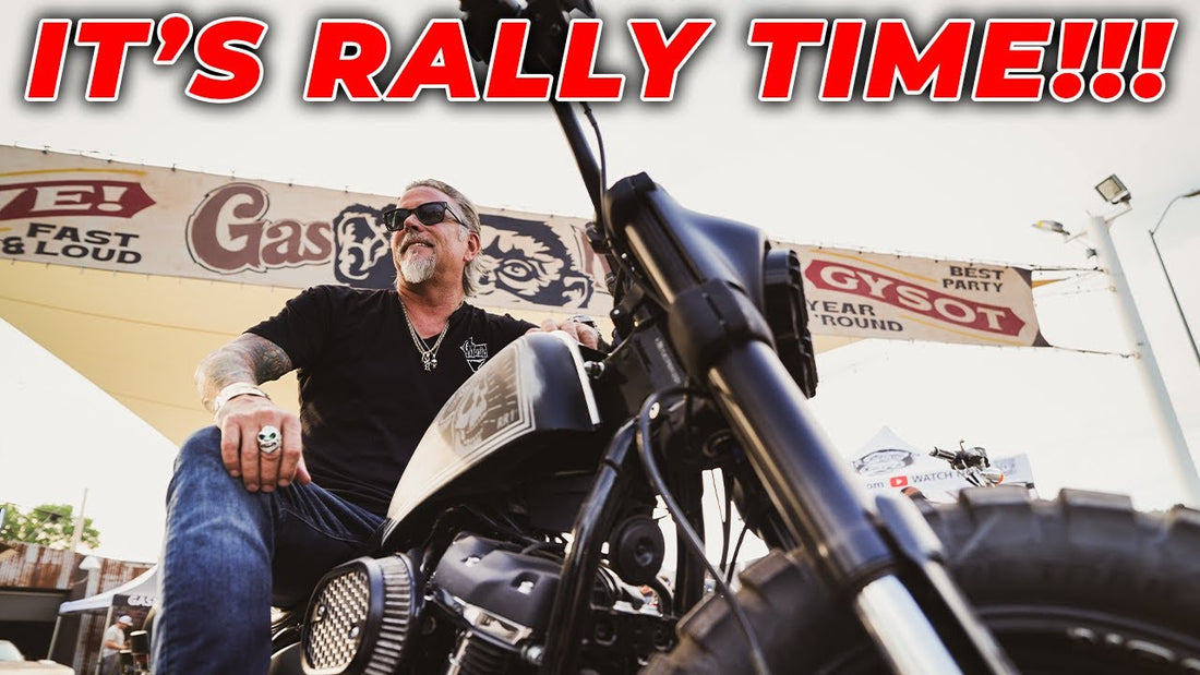 Man seated on a black motorcycle outside Gas Monkey Sturgis, with rally signage in the background