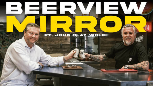 Two men toast at a bar beneath Beerview Mirror and Ft. John Clay Wolfe